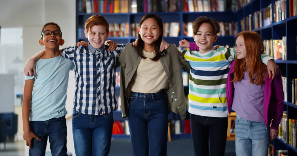 Happy friends at school at the library.