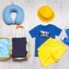 Suitcase with travel accessories for children on wooden background