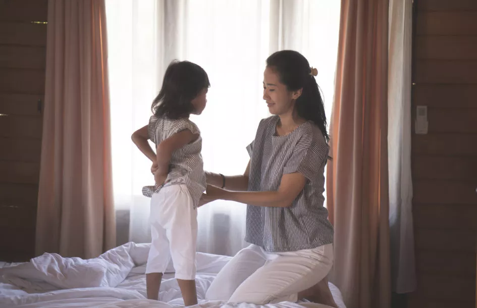 portrait woman and daughter prepared clothes, mother wearing clothes for daughter