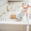 Little toddler boy getting out of a cot. Domestic accident. Dangerous situation at home.
