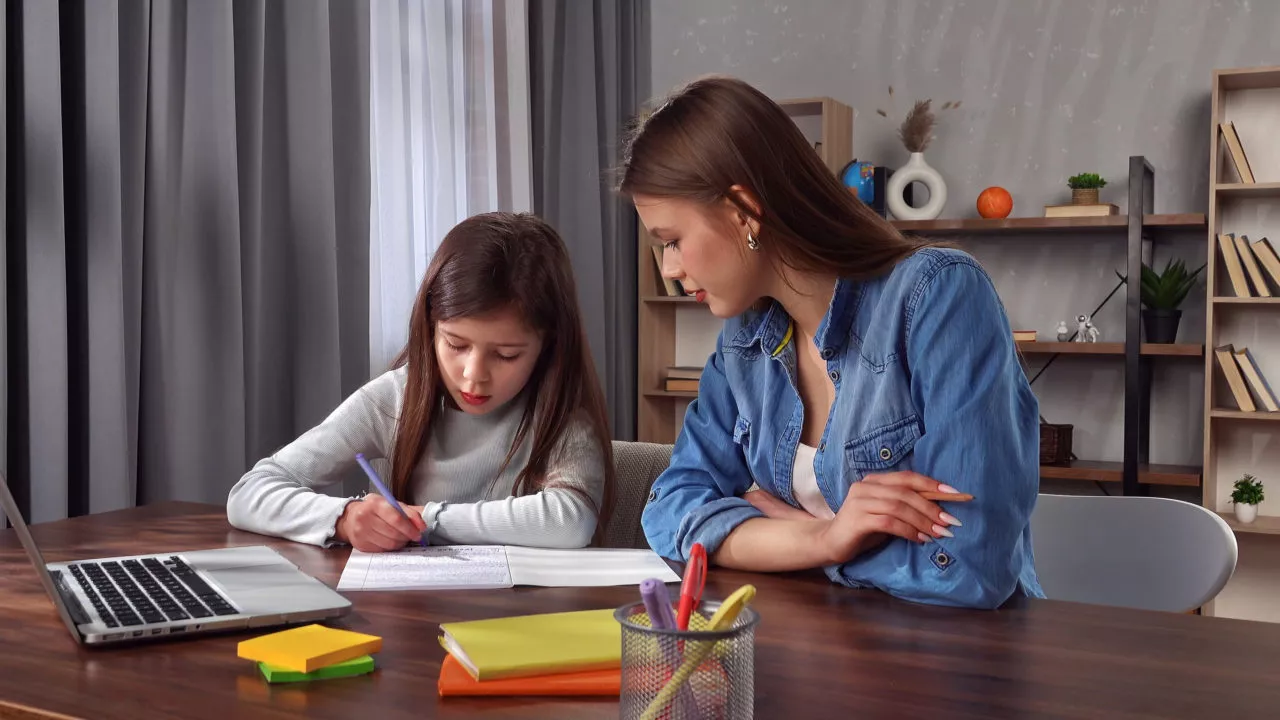 mom helping young girl with her homework routine