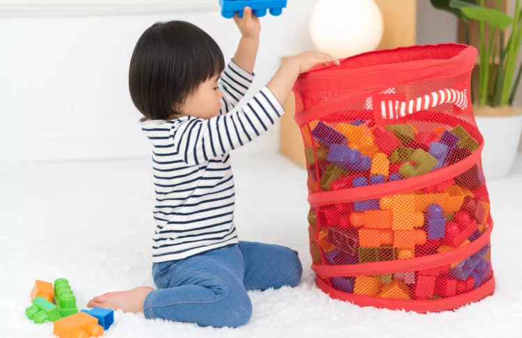 chores for school aged children. a child cleaning up some playing blocks