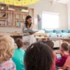 Early literacy in preschool: Teacher At Montessori School Reading To Children At Story Time