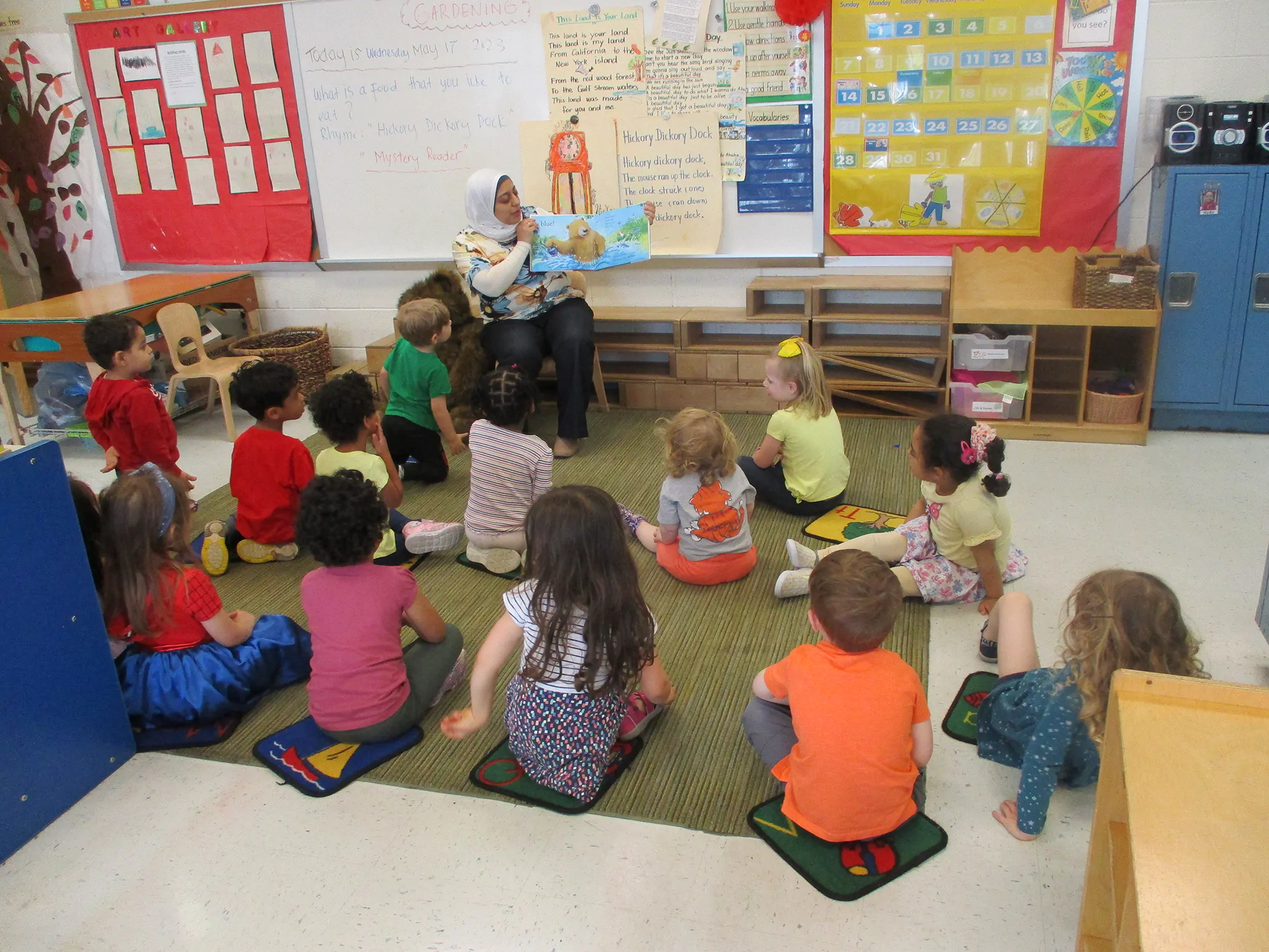 Arcola Preschool teacher reading a book to an attentive group of children during circle time.