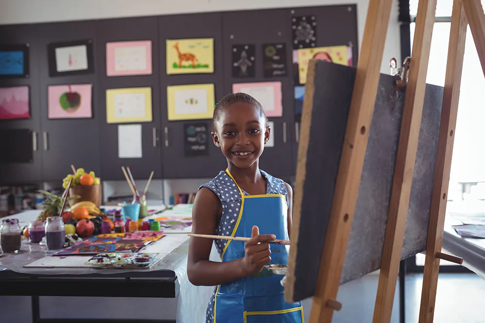 child wearing an apron and painting