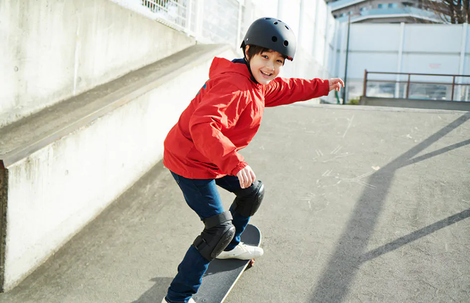 Child Skateboarding and happy with helmet on