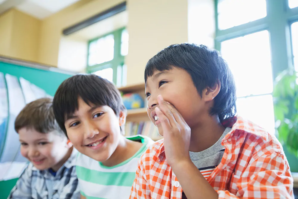 Three boys in childcare setting smiling and having fun together