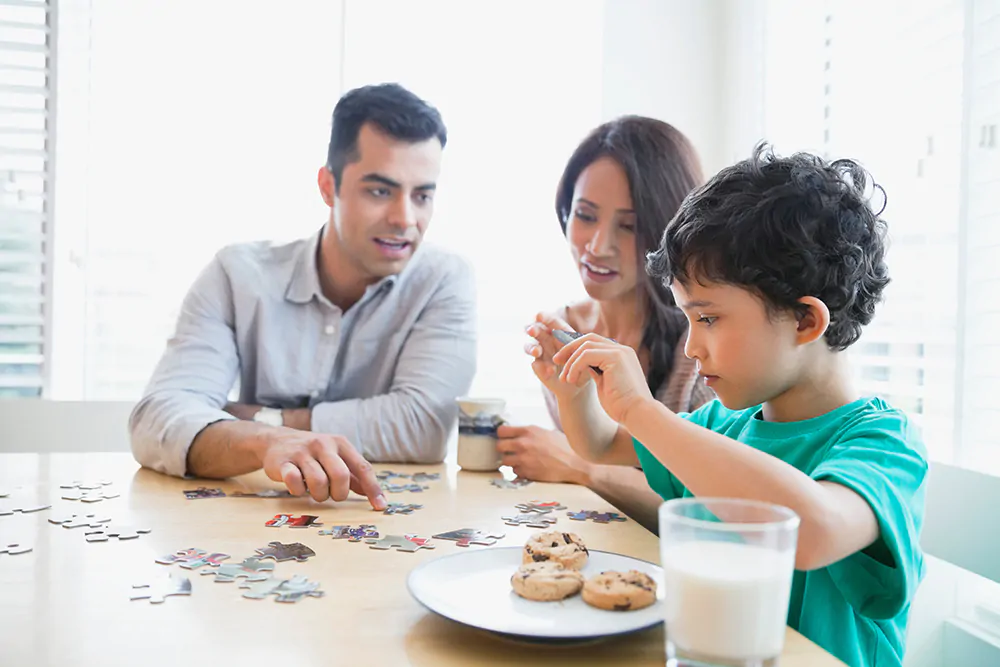 Family Creating a Puzzle while eating milk and cookies