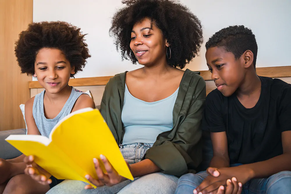 mother reading a book to her 2 boys