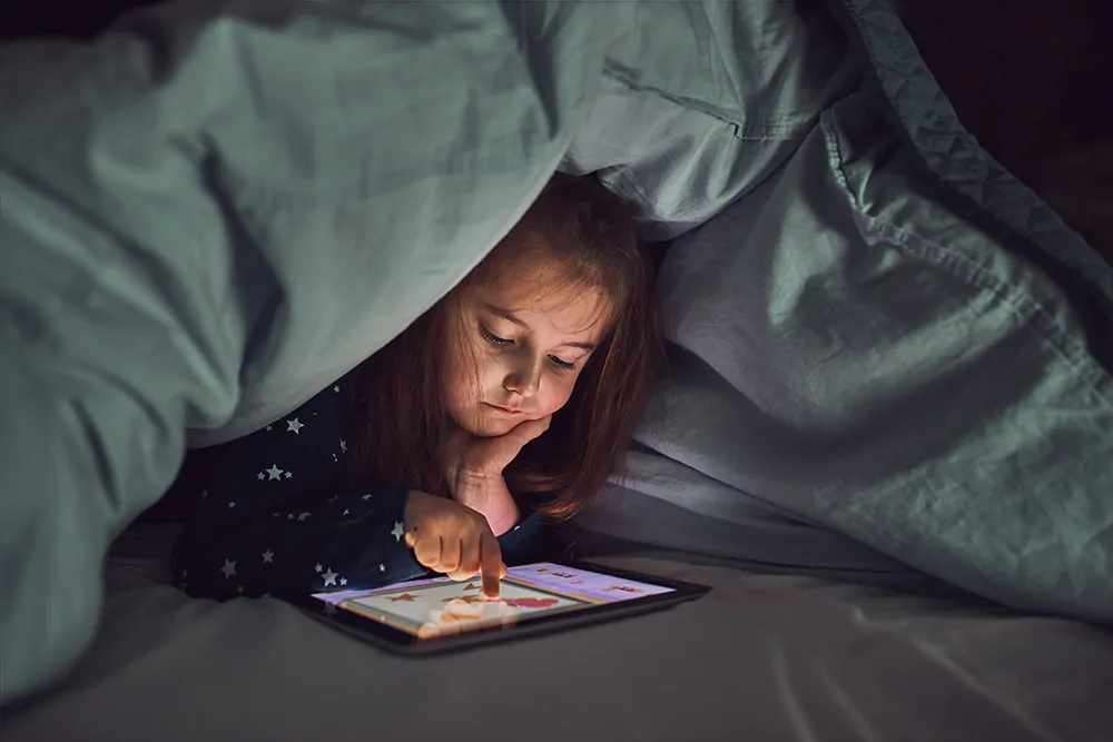 little girl playing on her tablet