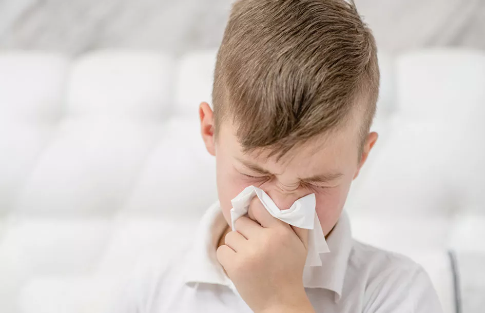 Sick child blowing his nose