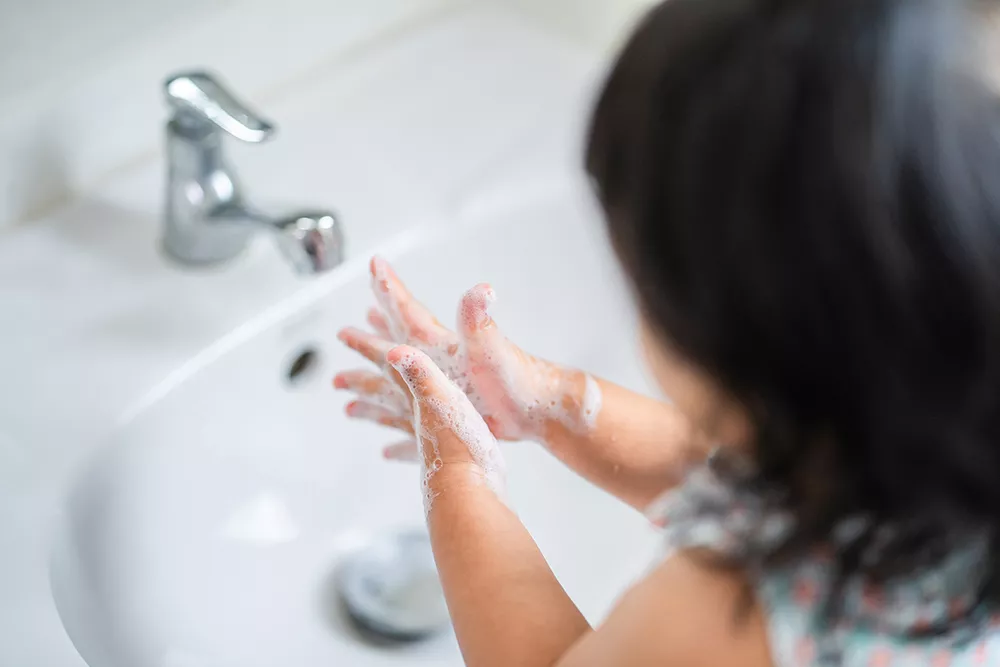 Little Girl is washing her hands to prevent virus and germs