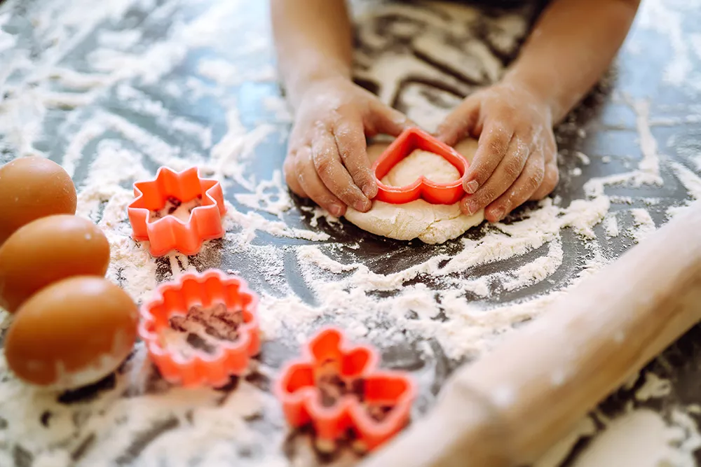 Kids baking during winter break with cookie cutters