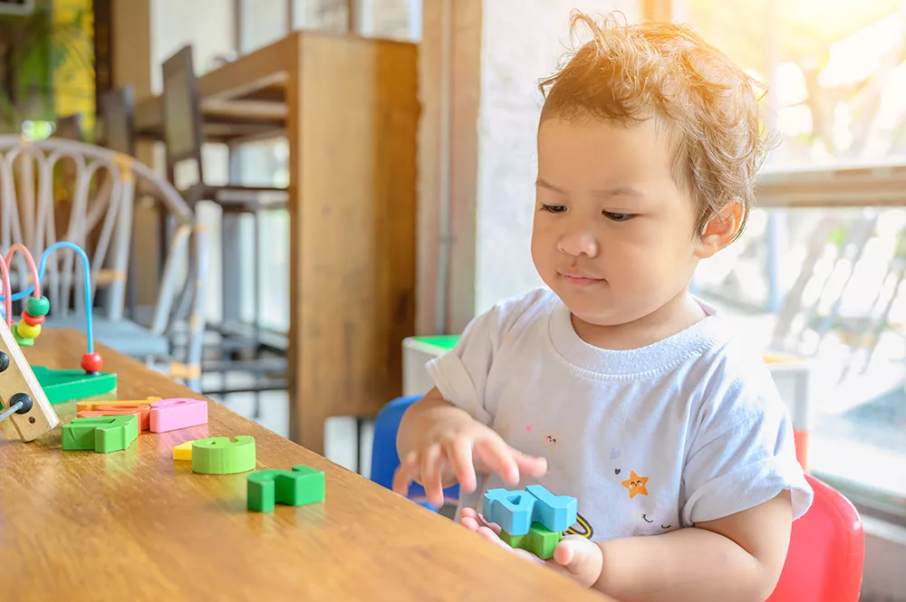 preschool boy playing with colorful toys