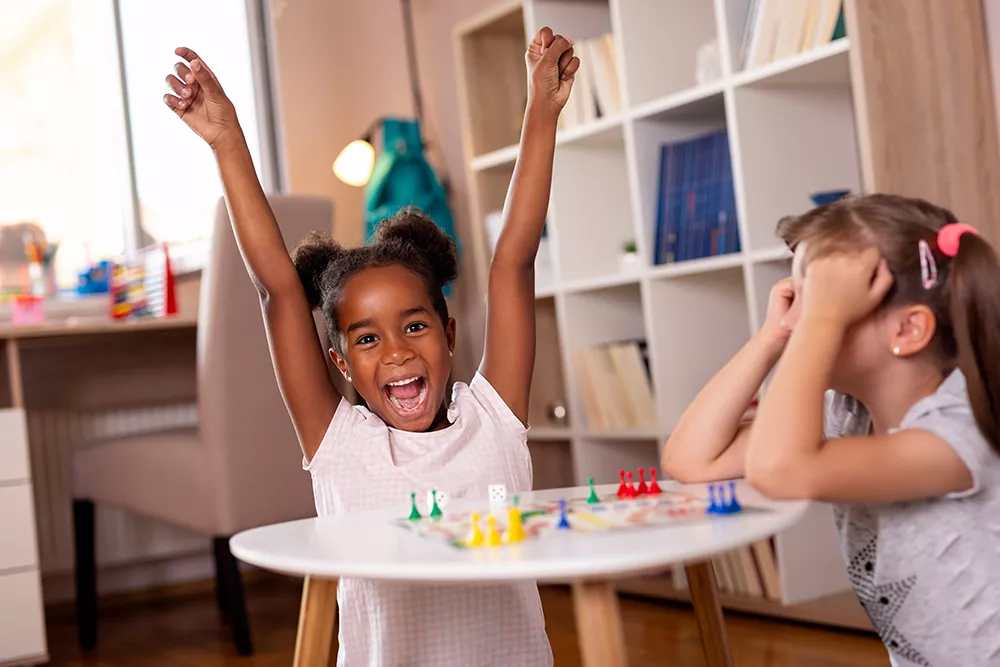 two preschoolers playing a boardgame