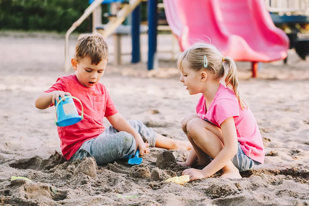 two children playing in a sand box together