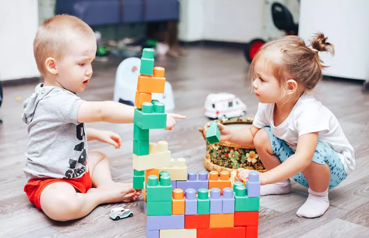 Toddler boy and girl playing with toys.