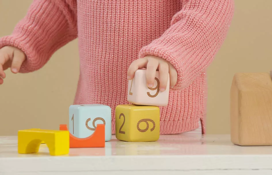 Toddler girl playing with wooden blocks