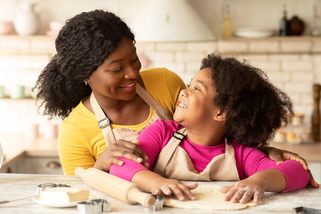 Girl Baking With Mother In Kitchen