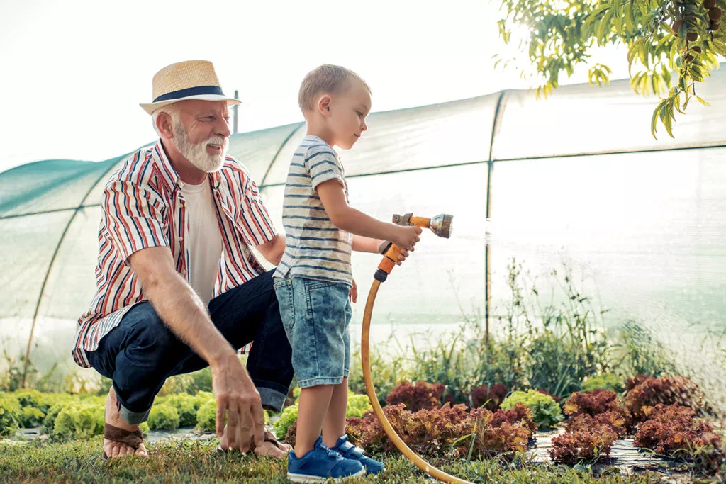 Grandfather with his grandson working in the garden