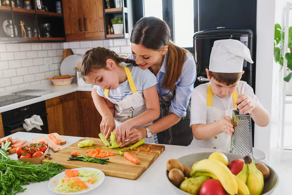 Cooking and Baking as Learning Tools, Mother teaching her kids to cook in the kitchen.