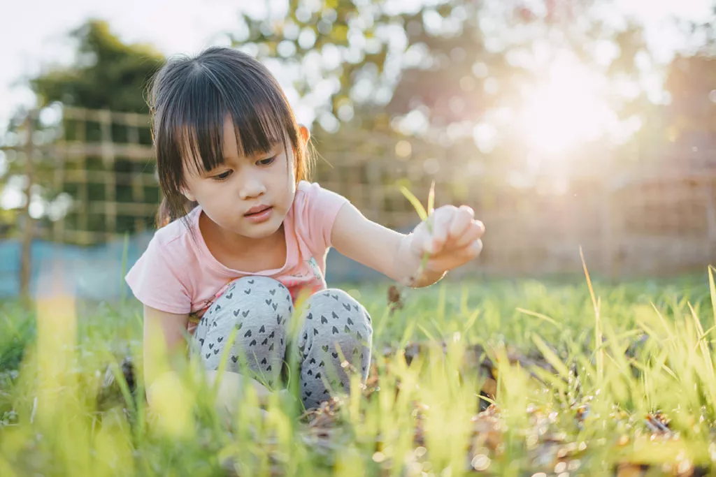 little girl playing and exploring outside