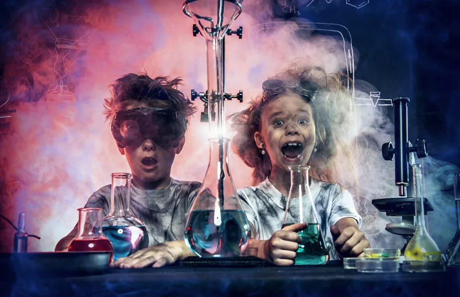 Funny school children doing experiments in the laboratory.