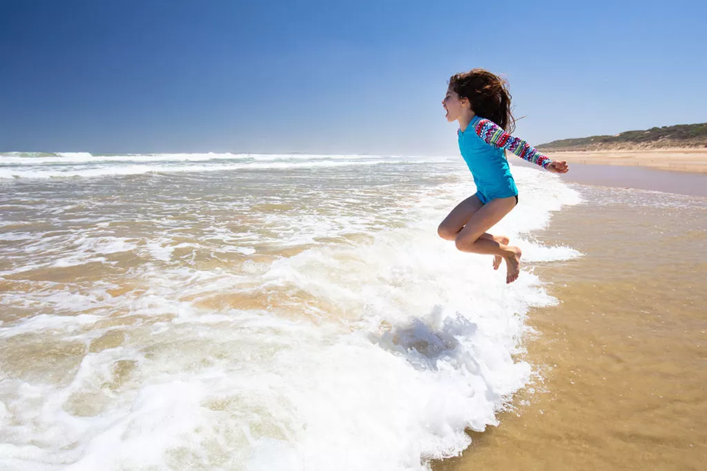 Joyous child playing in the waves