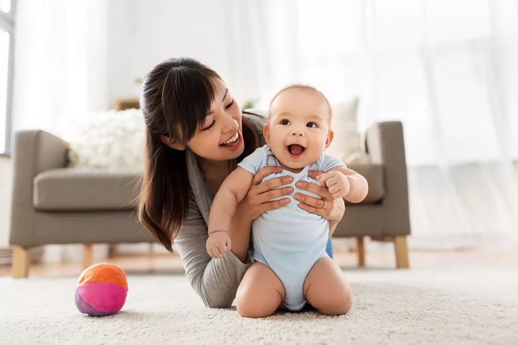 Happy mom holding her smiling baby.