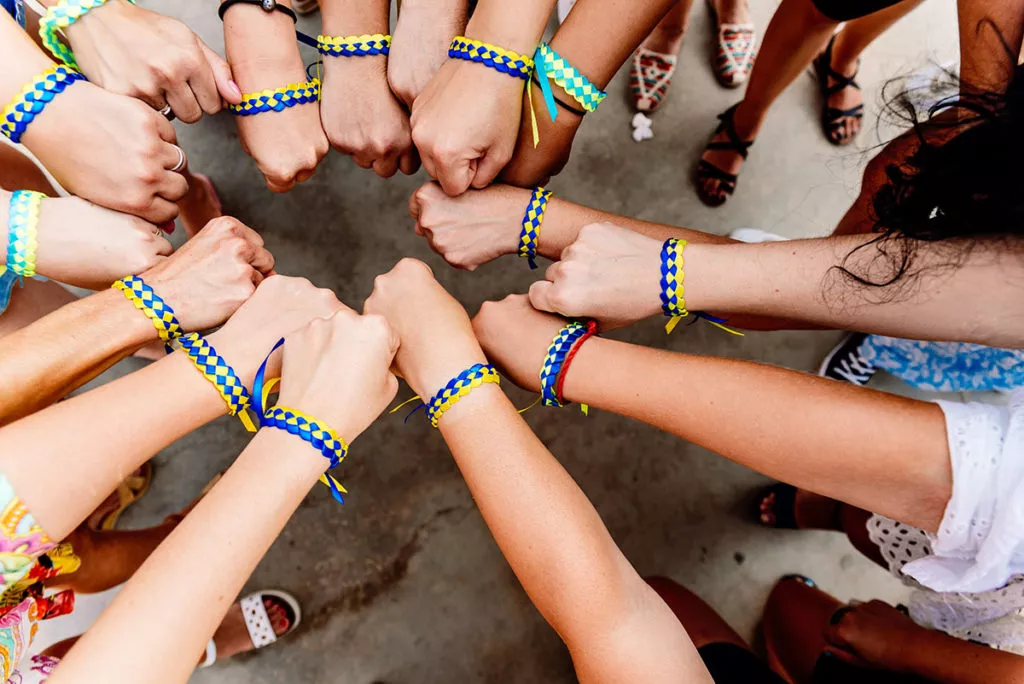 Friendship bracelets on wrist in a circle.