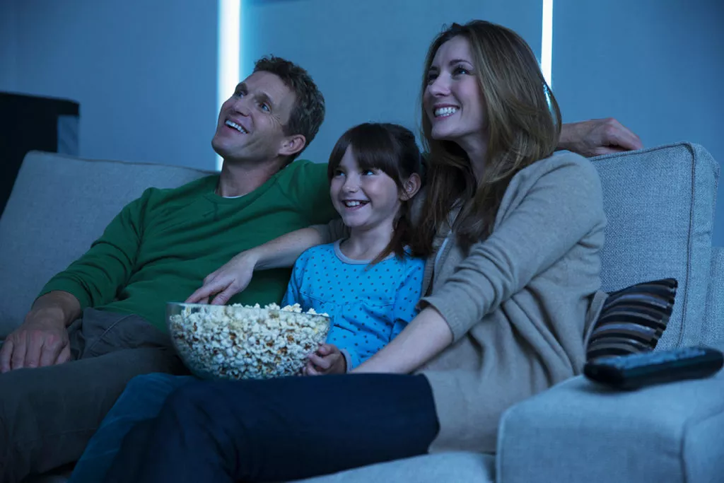 Family having a movie night at home with popcorn.