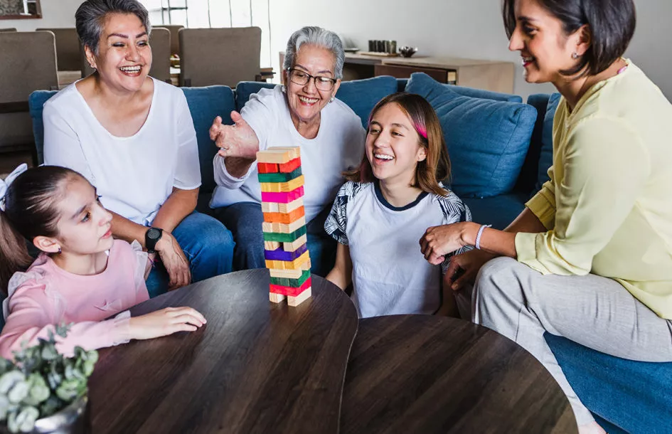 Family having game night together at home with kids and grandparents.