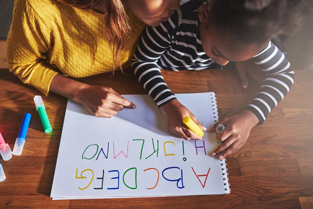 Overhead view of little girl learning the alphabet