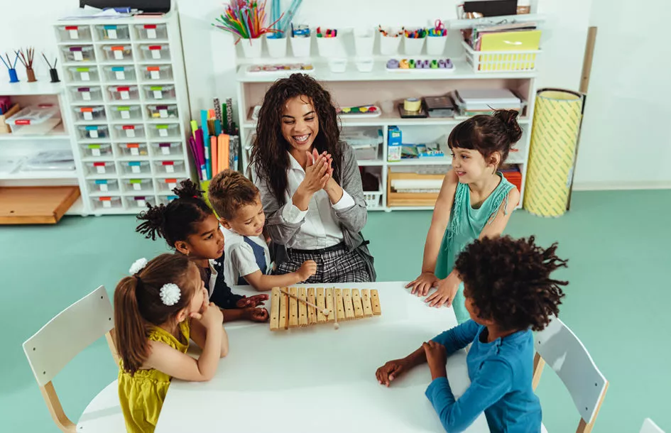 Teacher and kids sitting at a table in the Best Childcare Facility in Silver Spring.