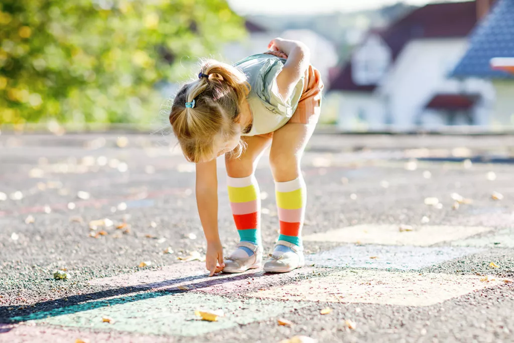 Cute little toddler girl playing hopscotch game as a Preschool Activities at home