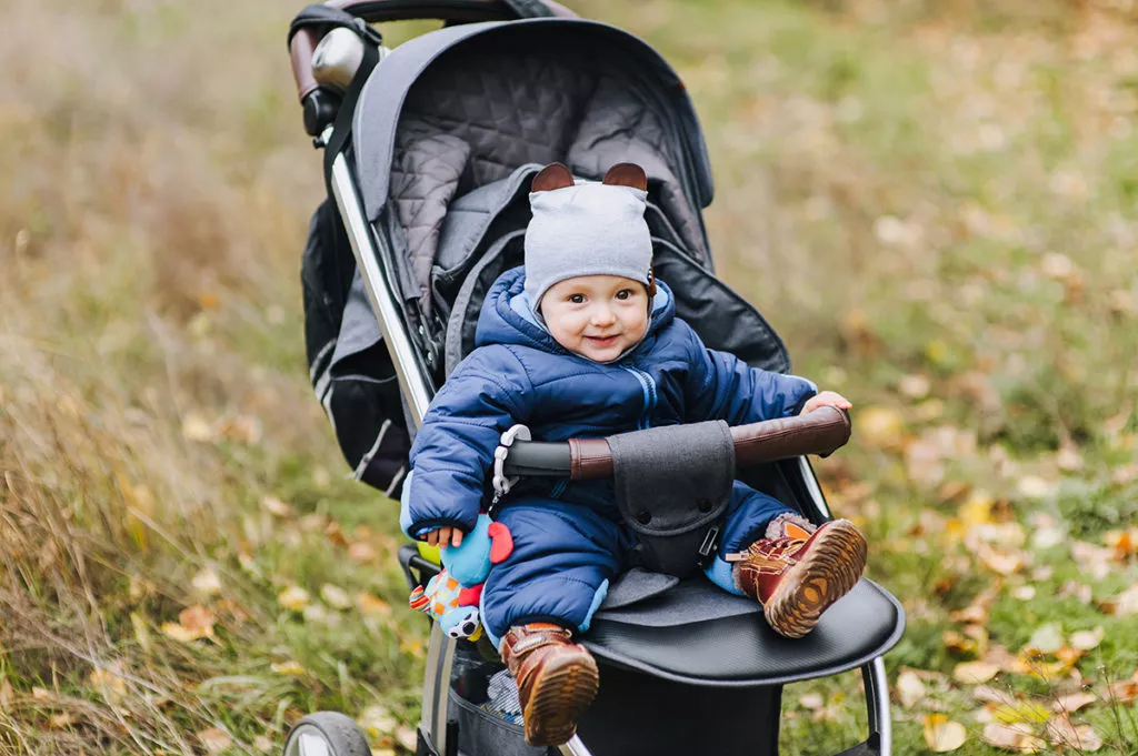 Baby sitting in a stroller bundled up in warm clothes on a cold day in Rockville, MD