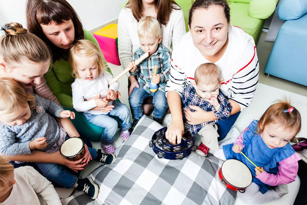 Moms with young kids at a music lesson for mommy and me.