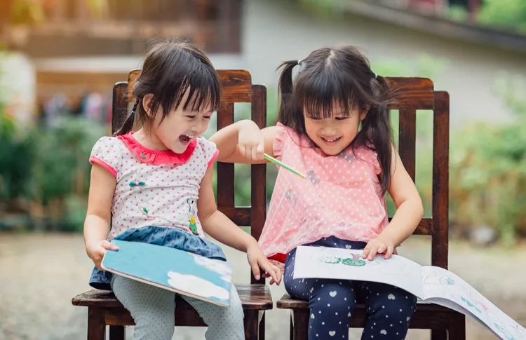 Happy kids at preschool in Maryland sitting and reading together.