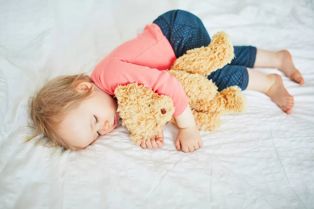Adorable baby girl sleeping with her favorite toy at a daycare in in Silver Spring, MD.