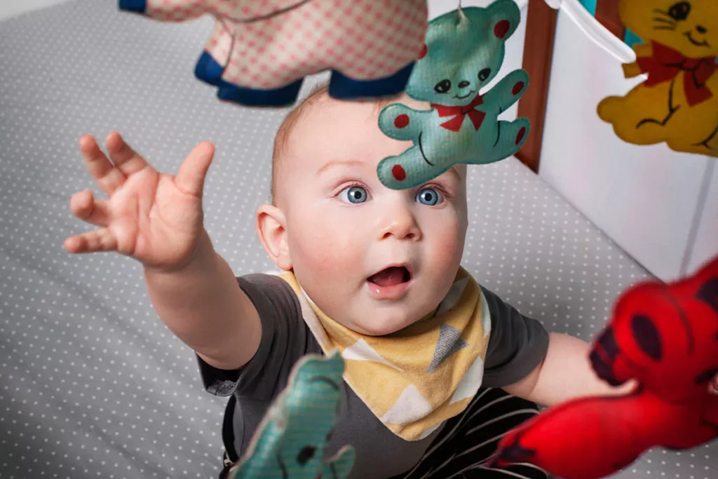 Close-up of playful baby looking at hanging mobile at an infant daycare in Rockville.