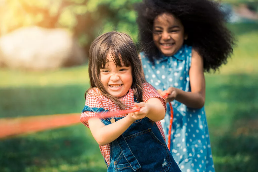 Happy children playing tug of war and having fun at a summer camp in Rockville, MD