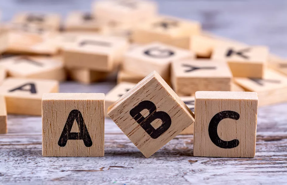 Wooden alphabet blocks symbolizing how Olney, MD, preschools help children build pre-reading skills, learn phonics, and expand their vocabulary.
