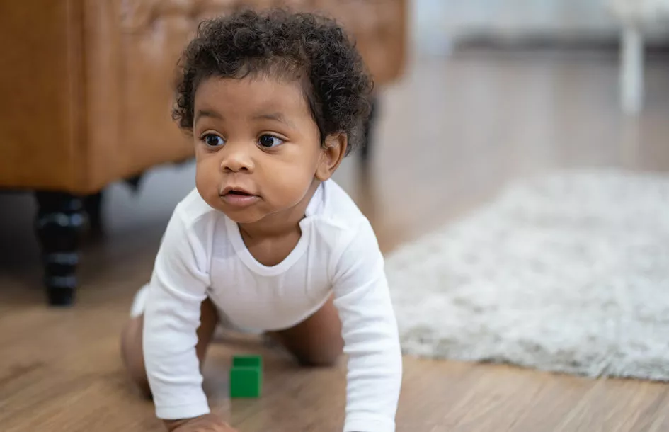 Happy toddler boy crawling and learning and building motor skills through fun activities.