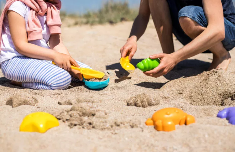 Beach day with kids. Family playing in the sand at the beach