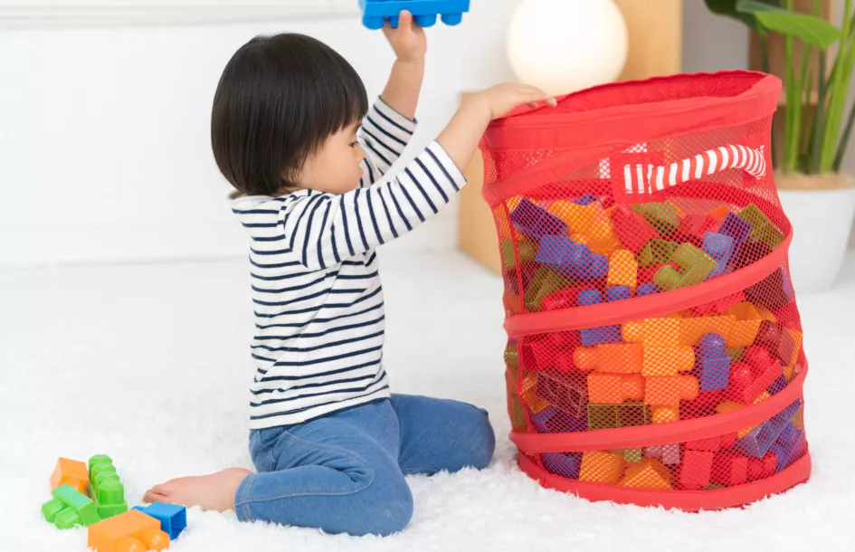 chores for school aged children. a child cleaning up some playing blocks