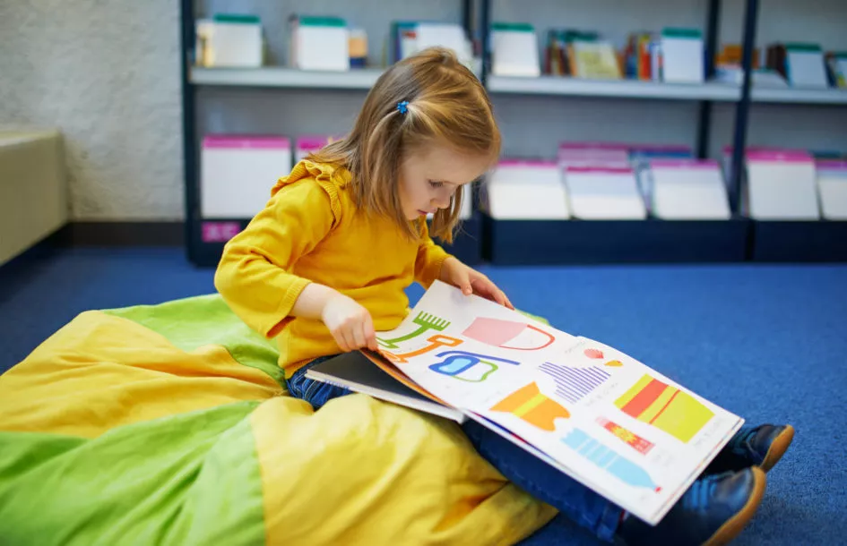 child reading a book as part of quiet time activities for preschoolers