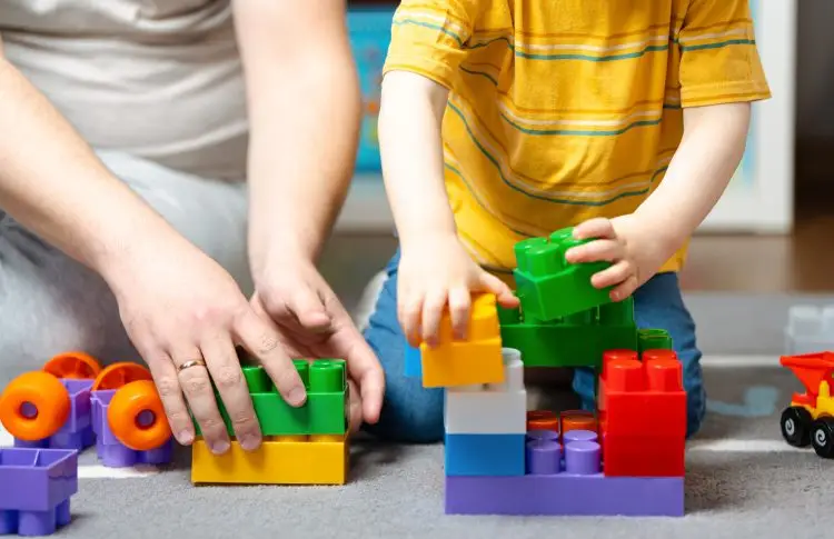 Little toddler boy playing building blocks, building problem solving skills in preschoolers