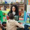 Signs of a quality preschool. Teacher sitting with preschoolers for story time