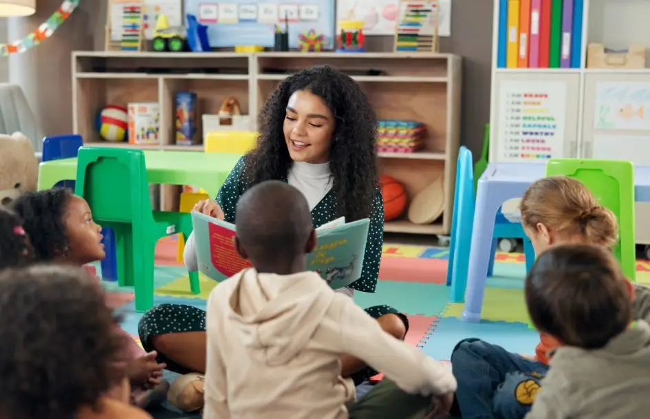 Signs of a quality preschool. Teacher sitting with preschoolers for story time