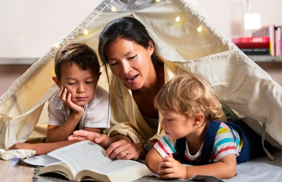 Summer reading tips for kids: mom reading in a fort to her two young boys